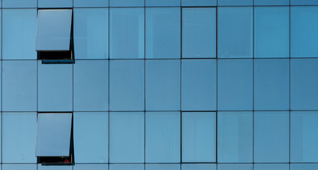 front view of a glass facade with opened windows