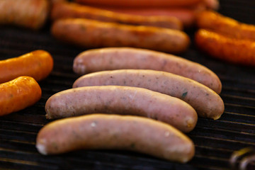 Grilled sausages on grill with smoke and flame in party night , selective focus