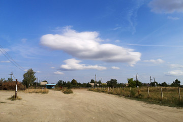Obraz premium Beautiful scenery. Cloud an unusual on the horizon. Blue sky and sandy road