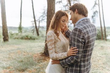 Fototapeta premium A young couple of brides walking in the pine forest