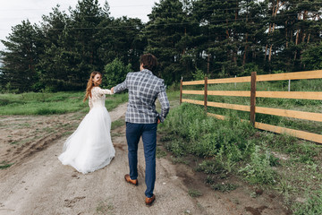 A young couple of brides have a fun and walking in the field outdoor