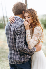 Fototapeta premium A young couple of brides walking in the pine forest
