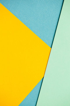 Photo of colored sheets of paper: yellow, orange, blue, green. Suitable for design templates, covers, banners, reports, abstractions, wallpapers