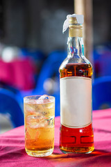 Glass of whiskey with near bottle whiskey
