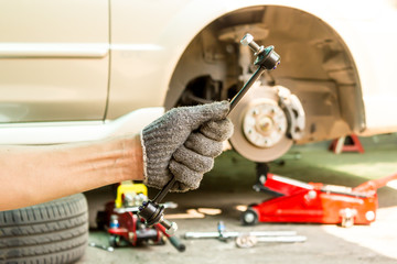Hand with Car Stabilizer control link, Close up.