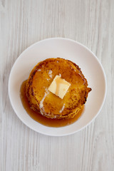 Homemade corn meal Johnny cakes  on a white plate on a white wooden background, overhead view. Flat lay, from above, top view.