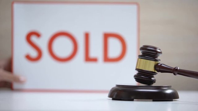 Gavel striking sound block against sold sign background, court decision, auction