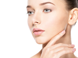 Young woman with healthy clean skin touches the face. Skin care concept.