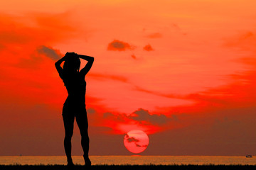 silhouette A happy girl on the beach on sunrise