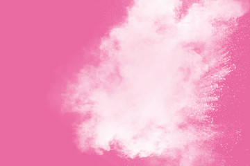 Abstract white powder explosion on pink background. Freeze motion of white dust splattered.