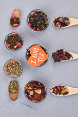 I love tea concept. Differnet kinds of dried tea on gray background, top view.