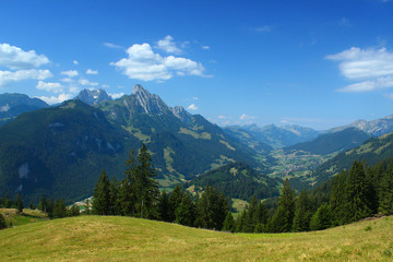 View from the mountains near Saanen, Switzerland, in summer 2019. At the right the village Rougemont. 