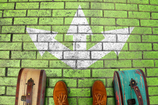 Man Feet In Suede Boots. Vintage Suitcases Stand On Paving Stone Green Road. White Arrows Point  Three Different Directions. Three Option To Make Decision Which Way To Go. Top View. Minimalist Image