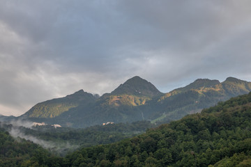 Fototapeta premium Beautiful mountains at sunset, fog. Peaks of mountains in Sochi, Russia