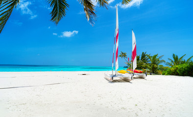 Boats for water activities in the Maldives lie on the shore in t