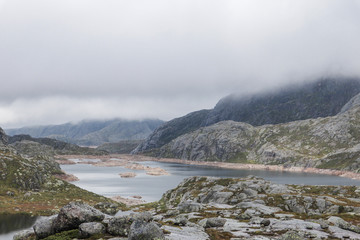 Beautiful blue lake in the mountains in the fog