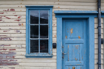 Fototapeta premium Window with a blue frame and a blue wooden door in a wooden wall