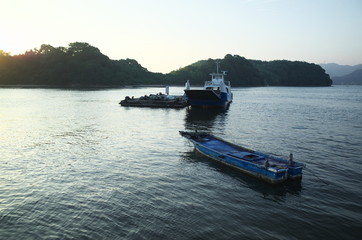 日本の朝日に輝く島と船