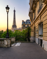 Cozy street with view of Paris Eiffel Tower in Paris, France. Eiffel Tower is one of the most iconic landmarks in Paris. Architecture and landmark of Paris. Eiffel tower in summer, Paris, France.