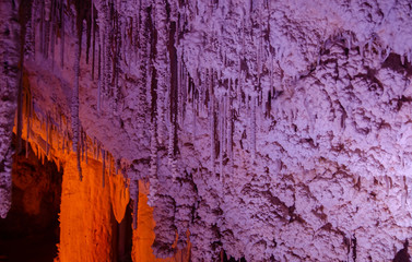 Colorful illuminated stalactites at Stalactites Cave also known as Soreq Cave and Avshalom Cave