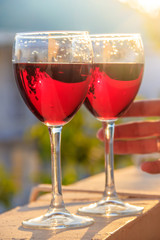 Two glasses of red wine are backlit by the sun. Grape drink.