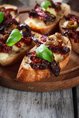 Appetizer bruschetta with sun-dried tomatoes, olives and mozarella.