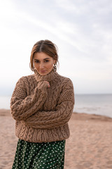 Pretty girl in brown sweater on the seashore