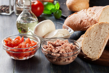 Ingredients ready for preparing bruschetta with tuna, mozzarella cheese and tomatoes