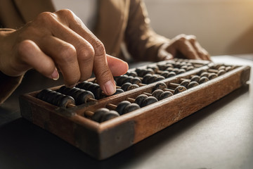 Asian woman hands accounting with old abacus. Financial design concept.
