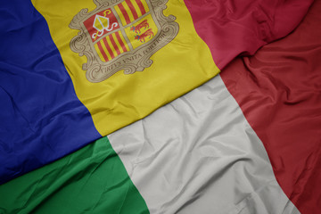waving colorful flag of italy and national flag of andorra.