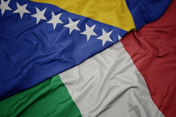 waving colorful flag of italy and national flag of bosnia and herzegovina.