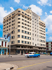 Old masonry building in Habana and colorful vintage cars, Havana, Cuba.