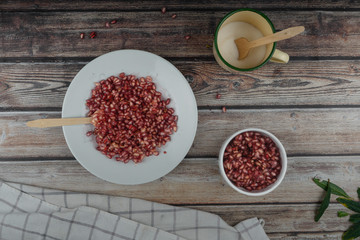 Pomegranate on stone plate with wooden spoon