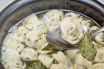 meat dumplings are boiled in a pot of boiling water