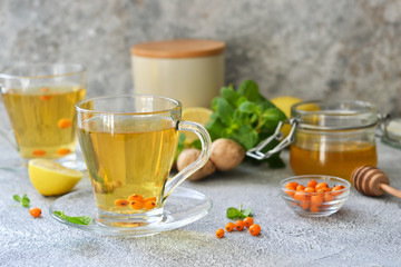 Tea with mint and sea buckthorn on a concrete background with space for text. Advertising.