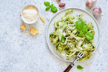 Tagliatelle with pesto on the kitchen table. View from above.