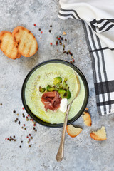 Broccoli cream soup on a concrete background. View from above.