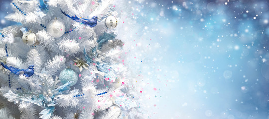 White Christmas tree decorated with silver Christmas balls and beautiful blue bird good luck on...