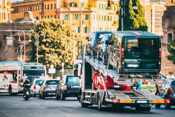 Fototapeta na wymiar Auto-transport Carrying New Fiat Cars In European City Street. Auto Transport Broker Or Car Transporter