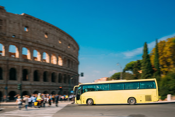 Rome, Italy. Colosseum. Yellow Bus Moving On Street Near Flavian Amphitheatre. Famous World UNESCO Landmark © Great Brut Here
