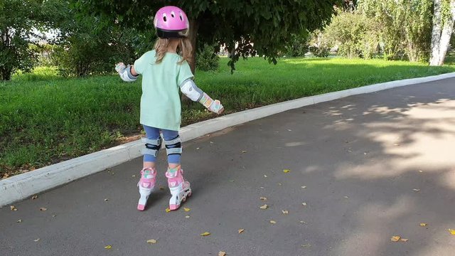 little girl learn to roller skate in the Park