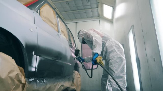 Mechanic is painting the car in slow motion