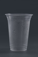 Empty plastic glass on a gray background.