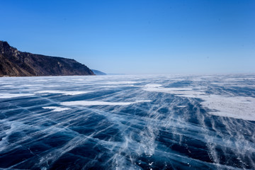Fototapeta na wymiar Frozen Lake Baikal. Beautiful mountain near the ice surface on a frosty day. Natural background