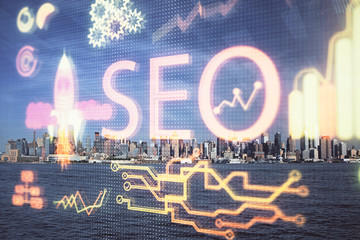 SEO hologram on city view with skyscrapers background double exposure. Search optimization concept.