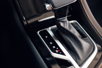 Plakat Selector automatic transmission with perforated leather in the interior of a modern expensive car. The background is blurred