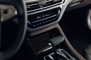 Modern car interior. Soft focus. Modern car illuminated dashboard. Luxurious car instrument cluster. Close up shot of automobile instrument panel. Blue interior light
