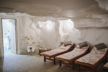 salt room in spa salon: relaxing beds in white interior