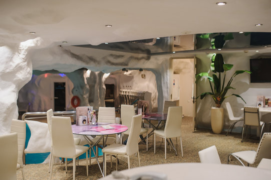 the interior of a fito bar in a spa centre: white tables and chairs