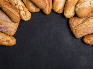 Copy space with different types of bread on black background